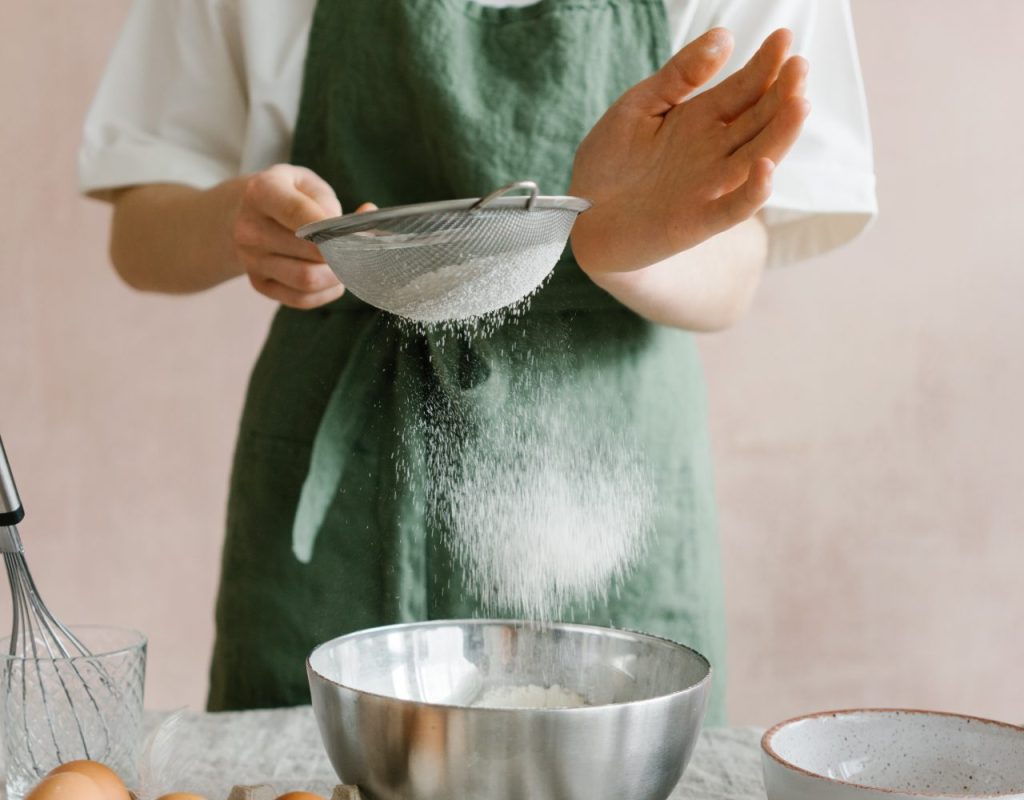 Préparation de l'appareil du flan pâtissier en tamisant la farine